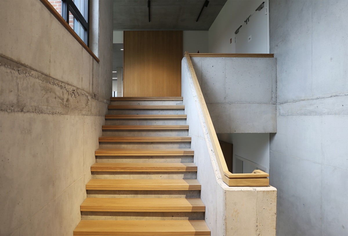 BOTZ Münster. Planung: HOFF und Partner. Treppe mit Sichtbeton und Holz.