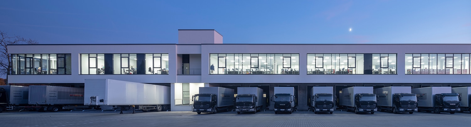 Gautzsch Münster Logistikhalle Neubau: Generalplanung und Schlüsselfertigbau HOFF und Partner. Verladerampen in der Dämmerung.